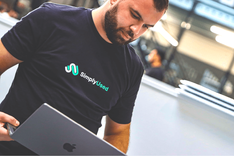 Een werknemer van SimplyUsed met een doos van een samsung smartphone in de hand. Illustreert het begin van het proces waar een smartphone wordt gecontroleerd tegen de ingegeven antwoorden van een klant.